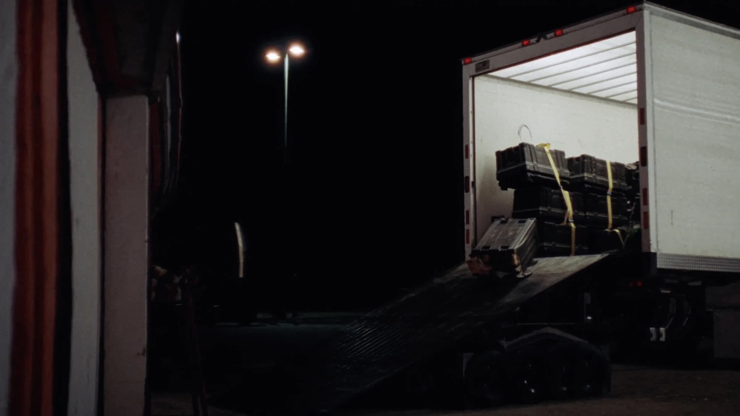 Un camión con la trampilla abierta y los flight cases sujetos con cinchas.